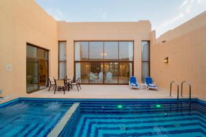 a house with a swimming pool and a patio at Western Hotel - Madinat Zayed in Madīnat Zāyid