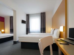 a hotel room with a bed and a desk and a laptop at B&B Hotel Prague City in Prague