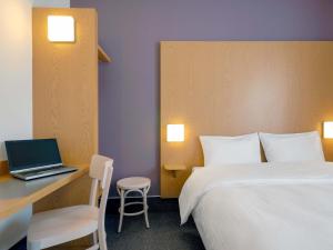 a hotel room with a bed and a laptop on a desk at B&B Hotel Prague City in Prague +18 photos