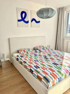 a bed with a colorful comforter in a bedroom at Krivoo Apartments III in Košice
