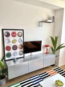 a living room with a flat screen tv on a cabinet at Krivoo Apartments III in Košice