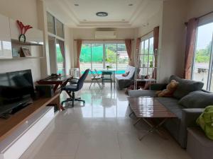 a living room with a couch and a tv at Cozy House in the center of Khon Kaen in Khon Kaen