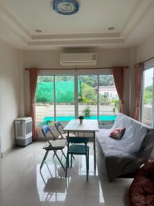 a living room with a table and chairs and a couch at Cozy House in the center of Khon Kaen in Khon Kaen