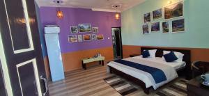 ビムタルにあるAasara Homestay Bhimtalの紫の壁のベッドルーム1室(ベッド1台付)