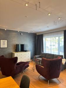 Una sala de estar con un sofá y sillas y una mesa. en HunsrückGlück Ferienhaus am Schinderhannes-Radweg, en Lingerhahn 49 fotos más