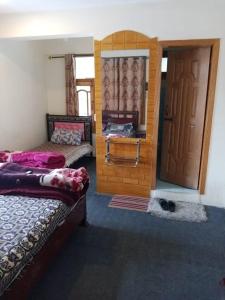 a bedroom with two beds and a door with a window at Burj-e-Alam Hotel in Karimabad Hunza +20 photos