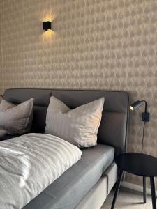 a couch with pillows and a table in a room at HunsrückGlück Ferienhaus am Schinderhannes-Radweg in Lingerhahn