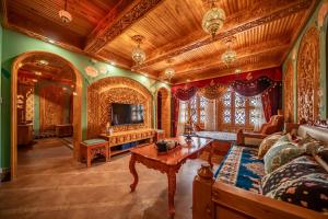 a living room with a couch and a tv at Wusong Guyi Western Regions Designer Courtyard in Yining