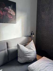 un sofá con una almohada blanca en una habitación en HunsrückGlück Ferienhaus am Schinderhannes-Radweg, en Lingerhahn