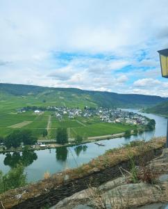 a view of a river with a town in the distance at HunsrückGlück Ferienhaus am Schinderhannes-Radweg in Lingerhahn