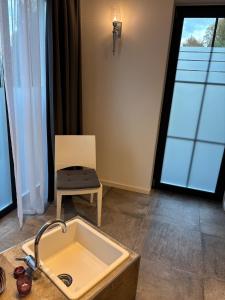 a kitchen with a sink and a chair and a window at HunsrückGlück Ferienhaus am Schinderhannes-Radweg in Lingerhahn +48 photos