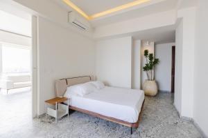a white bedroom with a bed and a table at Luxury Penthouse with Jacuzzi & Views in Puebla +31 photos