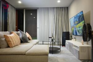 a living room with a couch and a tv at Villa Magenta Hua Hin in Hua Hin