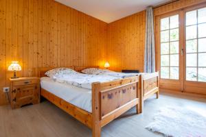 a bedroom with a bed in a room with wooden walls at Chalet Mon Reve in Blitzingen