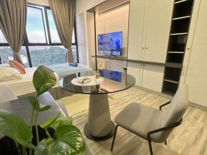 een kamer met een glazen tafel en stoelen en een bed bij Millerz square kuala lumpur in Kuala Lumpur