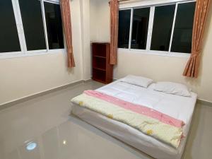 a small bed in a room with two windows at Cozy House in the center of Khon Kaen in Khon Kaen