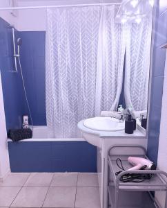 a blue bathroom with a sink and a shower at T2 Pineuilh avec parking privé in Pineuilh
