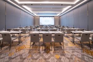a room with tables and chairs and a projection screen at Grande Centre Point Prestige Bangkok in Bangkok +46 photos