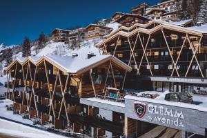 a ski lodge in the mountains with snow at GLEMM by AvenidA Superior Hotel & Residences in Saalbach Hinterglemm