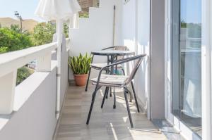 two chairs and a table on a balcony at Ostria Rooms in Palaiochora