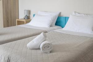 Dos camas blancas con toallas encima. en Ostria Rooms, en Palaiochóra