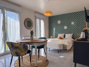 a bedroom with a bed and a table and chairs at Studio avec jardin et parking in Chartres