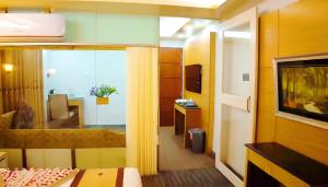 a hotel room with a bed and a television at The Ambassador Airport Hotel in Dhaka +30 photos