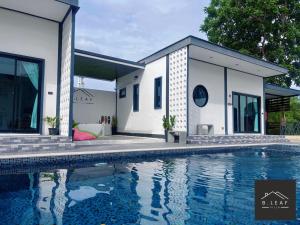 een huis met een zwembad ervoor bij B.leaf in Ban Hup Kaphong