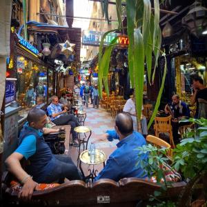 a group of men sitting in chairs in a market at Pa la ce court in Cairo