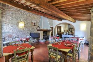 a dining room with tables and chairs and a fireplace at Agriturismo Il Selvino in Terricciola