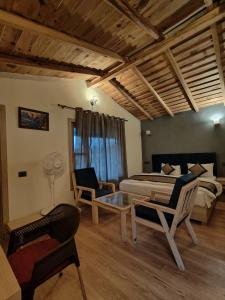 um quarto com uma cama, duas cadeiras e uma mesa em Garamcatcher em Haldwani-cum-Kathgodam