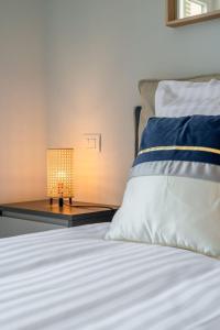 a bedroom with a bed with a lamp on a table at Le COQ Charlene - Monaco à 50m - New in Beausoleil