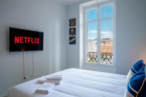 a bedroom with a bed with a tv on the wall at Le COQ Charlene - Monaco à 50m - New in Beausoleil