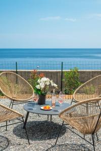 a table with three chairs and a table with wine glasses at Le COQ Jean Jaurès - Garage XL-AC- Monaco Border in Roquebrune-Cap-Martin