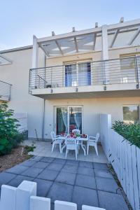eine Terrasse mit Tisch und Stühlen vor einem Haus in der Unterkunft Affittimoderni Isola Rossa Borgo Ulivi 19 in Isola Rossa
