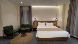 una habitación de hotel con una cama y una silla en Joya Hotel, en Phnom Penh 51 fotos más