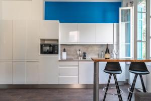 una cocina con armarios blancos y una mesa con taburetes en Le Coq Albert II - Monaco border - WiFi, en Beausoleil 14 fotos más