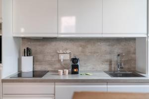 Una cocina con gabinetes blancos y un fregadero. en Le Coq Albert II - Monaco border - WiFi, en Beausoleil