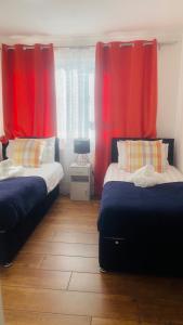 a bedroom with two beds and red curtains at Cozy plaza lodge in Rochester +19 photos