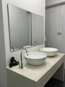 a bathroom with a white sink and a mirror at One life Hostel in Chiang Mai
