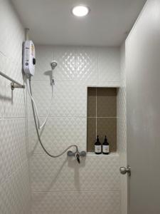 a shower in a bathroom with two bottles on a shelf at One life Hostel in Chiang Mai