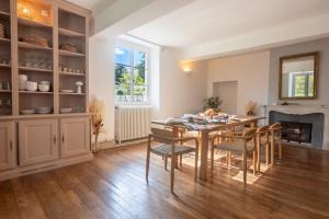 une salle à manger avec une table et des chaises et une cheminée dans l'établissement Château des Salettes, à Anoye