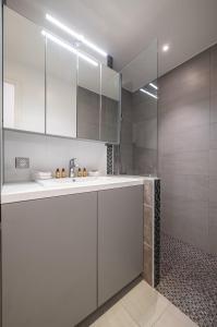 a white bathroom with a sink and a shower at Le COQ Symphonie - Parking - AC - WIFI in Menton