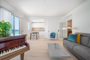 a living room with a piano and a couch at Le COQ Symphonie- Parking - Bord de mer in Menton +17 photos