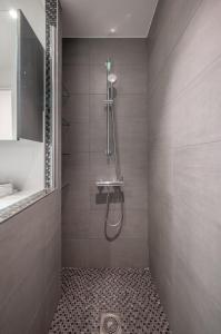a bathroom with a shower with a tiled floor at Le COQ Symphonie- Parking - Bord de mer in Menton