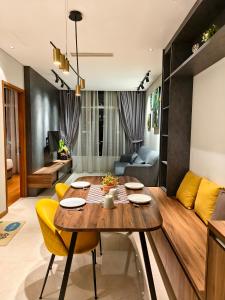 - un salon avec une table en bois et des chaises jaunes dans l'établissement Sky Suites KLCC Apartment by Family Room Stay, à Kuala Lumpur