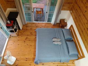 a large blue couch sitting on a wooden floor at Baan Klangkao - บ้านกลางเขา สะปัน in Ban Huai Ti