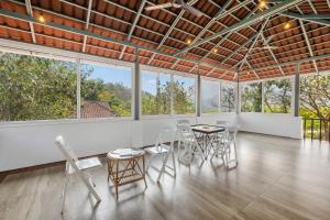 KorothClouds View Nature Resort的一间有桌子、椅子和窗户的房间