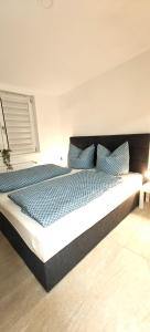 Un dormitorio con una cama grande con almohadas azules. en Seenland Getaway - Haus am Berg, en Pleinfeld