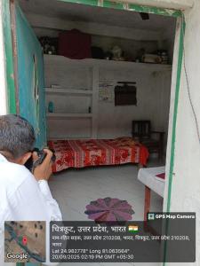 een man die een foto neemt van een bed in een kamer bij Kuldeep Mishra Rural Homestay in Karwi